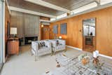 The original wood-burning cinder block fireplace remains intact, while clerestory windows allow light to pass between the kitchen and living room.