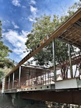 All on one level, Bridge House spans 210 feet across a stream in Hancock Park, Los Angeles. The structural undertaking was made possible by steel framework fabricated by BONE Structure.