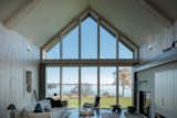 For this vacation home in Atlantic Canada, Acre Architects carefully studied each window opening in model form, testing the light quality and making adjustments as needed. At the rear façade, customized Marvin Special Shapes gave them the freedom to create the stunning showcase of symmetric gabled glass. Instead of a slick curtain wall, Acre chose multiple glass panes with visible mullions to add coziness and maintain the scale and feel of a cottage.&nbsp;