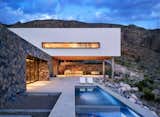 Against the backdrop of the mountains, the home’s upper volume appears from afar to float weightlessly in a sea of native grey rock, cacti, deep green agave, ocotillo, and yuccas that blanket the hillside.