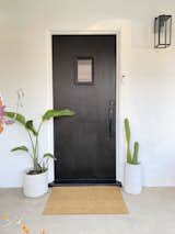 A bold black door makes a statement at the front entry – which is protected by a discreet video doorbell.
