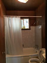 Before: The uninspired original bathroom features dropped ceilings and dated fixtures.