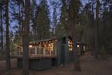 Nestled among the pines, the cabin twinkles at night.