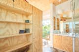 Adjacent to the bedroom, the airy and luminous bathroom is an inviting retreat. All of the home’s custom plywood cabinetry features integrated finger holes in lieu of cabinet pulls, keeping the overall aesthetic sleek and streamlined.