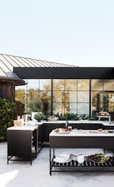 A striking kitchen that would look just as at home indoors or out, this setup from Crate &amp; Barrel’s Alfresco Collection oozes modern elegance. Bold powder coated bases, and marble-like veined quartz counters provide the perfect backdrop for open air entertaining.