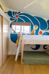 In one of the two kids’ bedrooms, a colorful mural by Taylor Bringhurst cascades down the wall. "She pulls in awesome colors and groovy movements that look like little waves and the sunshine," says Leah. "We love it."