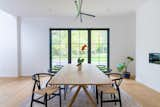 The light-filled dining room—the anchor point of the "L" on the home’s first floor—overlooks lush greenery in the front yard.