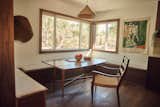 Off of the kitchen, the cozy dining area features a pendant from Twenty One Tonnes, canvas wall art from Upton, circular wood wall art from Brian Grasela, and dining chair from Hati Home.