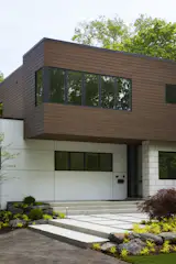 TimberTech Cladding in English Walnut graces the upper volume of the Highland Park home. The home’s modest height and horizontal massing seamlessly fits in with the context of the existing homes in the neighborhood.