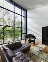 Overlooking the pond, the home’s living room, located in the western wing, is a bright, voluminous gathering space for the family.&nbsp;