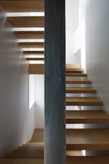 Open Tread White Oak Risers Wrap a Black Steel-Clad Wall to the Second Story