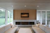 The Fireplace Wall in the Living Space is Composed of Black Steel Log Niches, Gray Marble, and White Oak