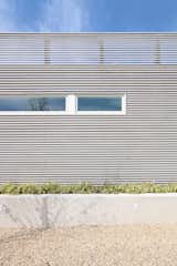 Poured-In-Place Concrete Retaining Walls Form Planters, Cedar Slats Provide Relief to the Garage Facade