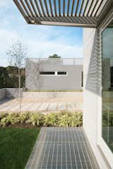 Cedar Brise Soleils Control Solar Gain, Metal Grating over Lightwells Allows Daylight into Basement Playrooom and Bedrooms.