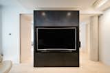 Glass Doors Pocket into the Black Steel Volume to Separate the TV Room from Living Space