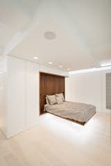 A Custom Built-In Walnut Bed Looks Like It's Floating with Linear Lighting Below