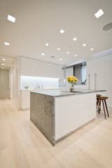 Kitchen, Undermount Sink, Recessed Lighting, Light Hardwood Floor, White Cabinet, Stone Counter, Accent Lighting, and Stone Slab Backsplashe A Marble-Wrapped Island Adds a Natural Element to the Minimal White Kitchen  Photo 14 of 20 in Upper West Side Apartment by Resolution: 4 Architecture