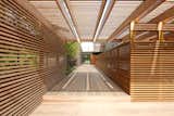 Exterior, Flat RoofLine, House Building Type, Prefab Building Type, and Wood Siding Material Approach from Autocourt to New MODERN MODULAR Prefab Guest Wing with Cedar Trellis and Slat Walls  Photo 15 of 16 in PSJ25 Patio by Kumiko Toft from Amagansett Addition