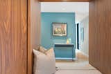 Mirror at custom walnut built-in bench makes the foyer feel more generous.