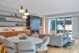 The dining and living space is anchored with a wall of walnut cabinetry and floating shelves to the north.