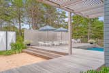 The pool deck uses a cedar slat screen wall to screen the neighbors from view.
