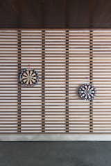 The slatted volume anchoring the carport serves as a storage shed, doors hidden around the backside.