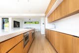Custom white oak cabinets and corian countertops provide a aesthetically minimal, yet highly functional kitchen in the open living space.