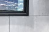 The material palette of gray cement board and black windows is simple and understating, so the view is the focus.