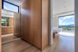 A dressing room separates the primary bedroom and bathroom with custom white oak built-ins and views of the mountains.
