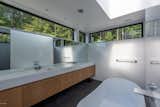 The primary bathroom is wrapped in high windows allowing for light and view while maintaining privacy. A large skylight over the master tub floods the bathroom with more daylight and provides a view of the sky when soaking.