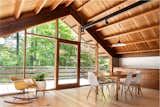 The dining area receives a bevy of natural light, while the cantilevered deck gives the sensation of being suspended in the trees.