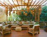 A new covered seating area was created on the existing redwood deck, with hanging basket lamps inspired by decorations Sharp created for the couple's wedding.