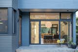Keyan Mizani demonstrates how the movable glass doors in front and back can make the great room one free-flowing, indoor-outdoor space.  Photo 7 of 9 in Budget Breakdown: An Architect Couple Build a Net-Zero Home and Studio for $250 Per Square Foot