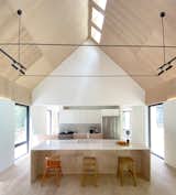 A vaulted ceiling interspersed with skylights, in tandem with floor-to-ceiling glass, fills the home with natural light.
