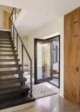 Tight confines meant only a few feet of foyer before giving way to the stairway and kitchen, yet the small footprint (and a glass door) helped fill the home with natural light.