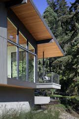 The Douglas-fir-clad ceiling extends from indoors outward to form a covered walkway, which cantilevers over the small culvert running beneath the house.