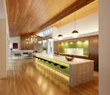 The kitchen, with copious island seating, is illuminated by hanging globe lights and clerestory windows.