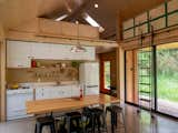 A modest kitchen is tucked at one end of the great room, illuminated not only by two walls of glass but a pair of skylights above.