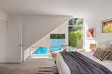 Beneath the stairway, a downstairs bedroom sneaks a view of the pool.