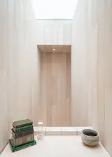 A small balcony-like alcove between the kitchenette and living area was created by the L-shaped stairway and the skylight.
