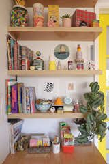 Open shelving at the living room desk provides a spot for collectibles and ephemera.