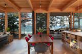 After moving up the entry stairs, a view of the combined living, dining and kitchen area, as well as the covered outdoor deck  Photo 6 of 14 in A Floating Living Room Sets a Family’s Lake Michigan Cottage Apart From the Rest