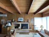 The living room's original 1940s pine ceiling and brick fireplace were preserved, but not the wood paneling from a 1970s renovation.