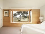 The new master bedroom includes a bay window protruding outward from the original facade, making a window seat that frames a view of shore pines and the dunes.
