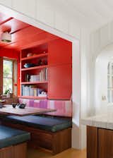 Located off the kitchen, the red-painted nook has a built-in booth, shelves, and storage, and it’s become a popular spot for everyone to convene in the home.