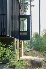 Protruding outward from the north and south facades (at its entry and kitchen) are small angled bump-outs that provide a view east and west while also acting as awnings.