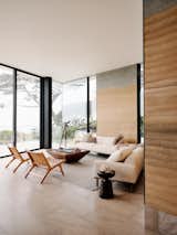 Glass walls wrap the home's western, ocean-facing side, with large glass pieces framed in the same black steel as the adjacent rammed-earth wall panels.  Photo 4 of 8 in exterior by Adam Lavey from A California Retreat Has Walls Made Out of the Beach