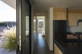 One continuous hallway goes across the house, from carport to great room to bedrooms. It allows the house to be expanded with an identically-designed twin, simply extending the hallway.  Photo 5 of 12 in Near Joshua Tree, a Sublime Desert Home Embraces Shadows and Sunlight