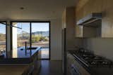 The kitchen island is topped with an extra-thick slab of Caesarstone, giving it a sculptural presence.