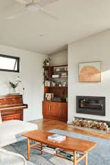 Instead of commissioning custom casework, as originally planned, the couple saved money by finding vintage furniture, such this corner shelving unit, complemented by a vintage midcentury coffee table.